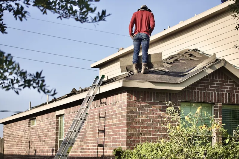 Professional roofer working on a residential roof in Hazlettville